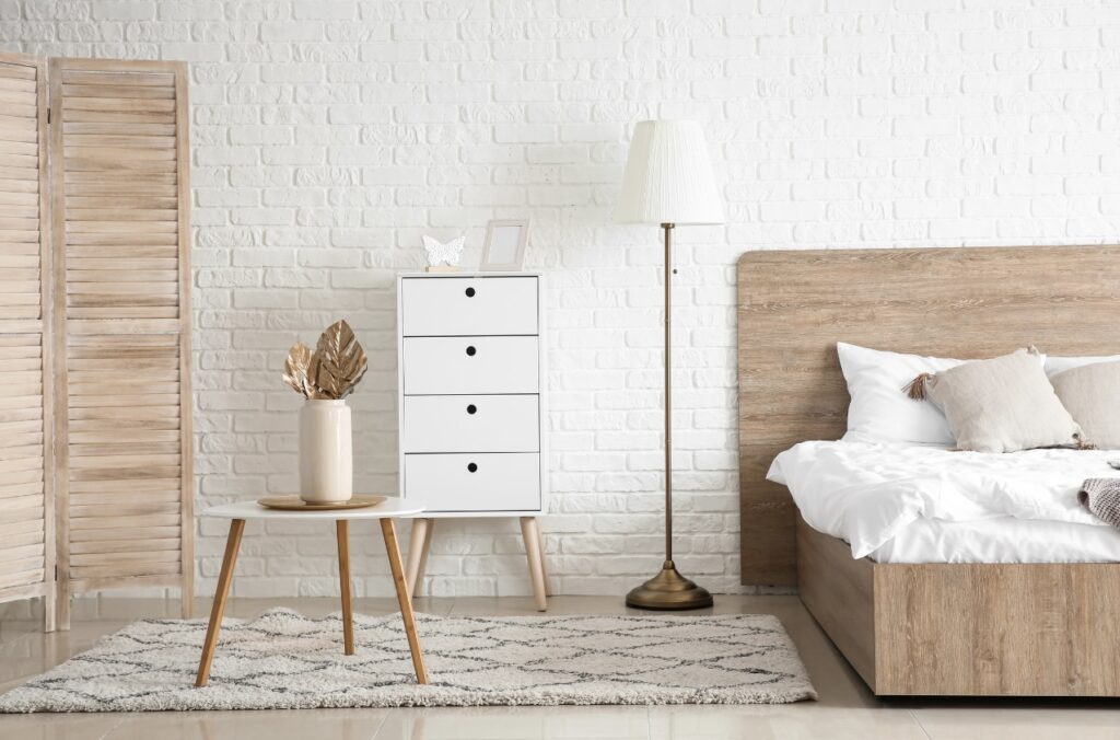 Chambre meublé blanche et beige tendance déco en 2025. Li en bois, table basse, grand tapis et commode 